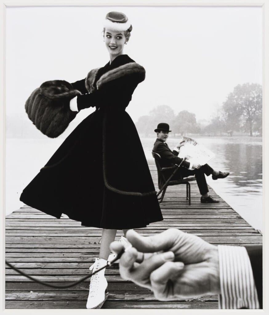 Skater in a Digby Morton fur trimmed velvet coat and city gentleman Michael Bentley in the background (1955)